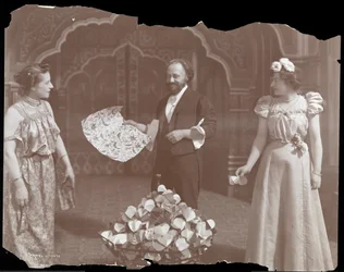 Professor De Kolta på scenen med två kvinnor, 1902 (silvergelatintryck)